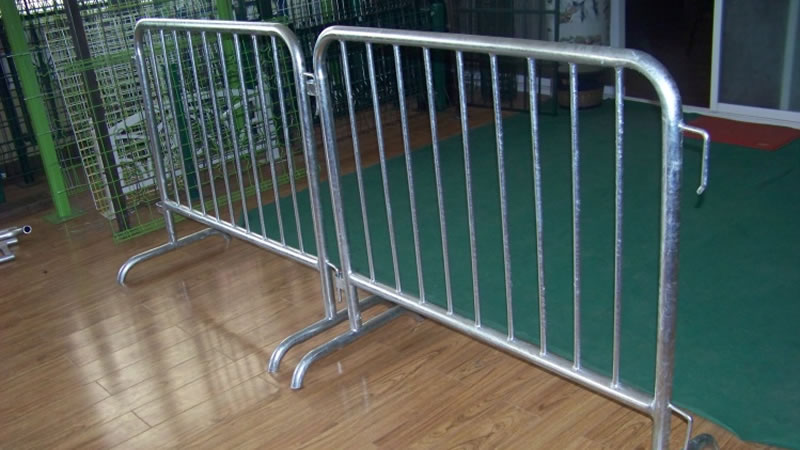 Two crowd control barriers with bridge feet are standing on the floor.