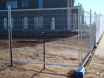 Around a construction site, the square top welded temporary fence is installed to separate the building and the road.