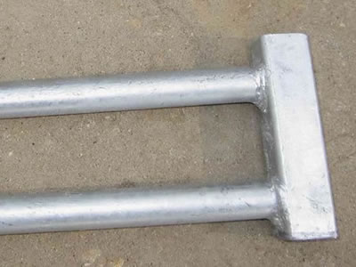 A galvanized Canada temporary fence clamp on the ground.