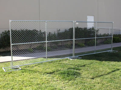 Two large size chain link temporary fences on the lawn. The fence panels have cross reinforced pipes.