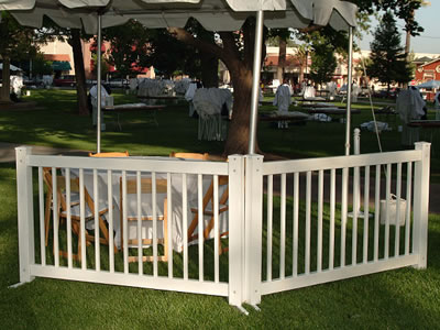 Two traditional type event fencing panels install next to the chairs and desks. A tent is set up next to them.