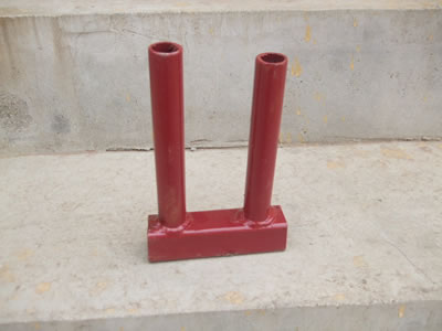 A PVC coated Canada temporary fence clamp on the concrete and it is painted with red.