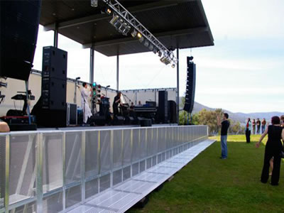 A long row of aluminum stage barrier is installed before the performance stage.