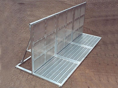 An aluminum stage barrier on the ground with extended front board supporting.