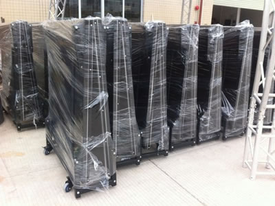 Many folded stage barriers are packaged with the plastic film and they are standing on the floor.
