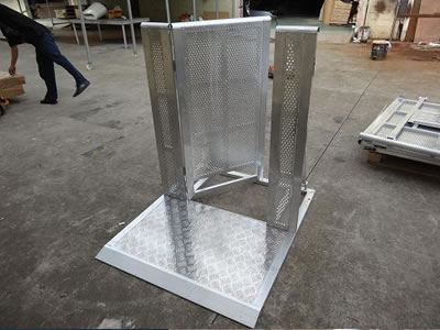 An aluminum stage barrier gate on the ground and its door is opening.