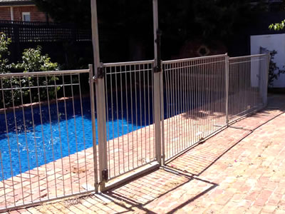 A temporary pool fence gate is installed with temporary fence around a swimming pool.