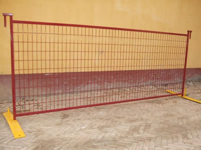 A red Canada temporary fence installed with the yellow flat feet standing on the floor.