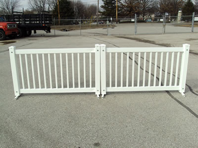 Two white traditional type event fencing panels on the road.